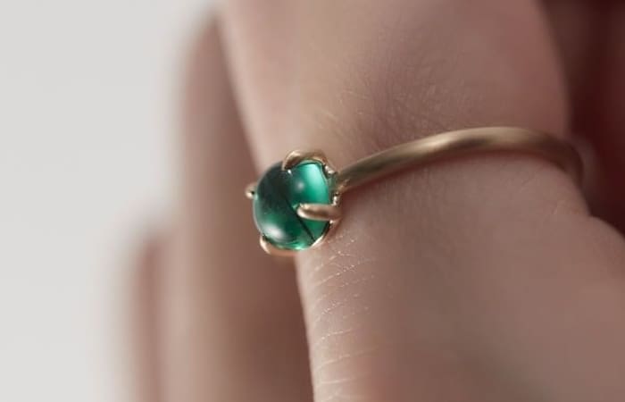 Emerald ring on finger